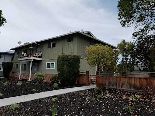 A house with a grey roof and a brown fence.