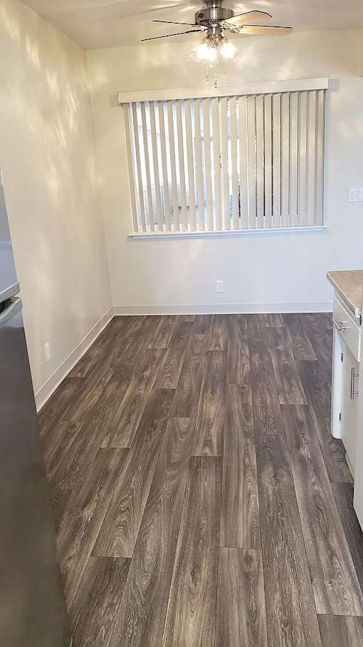 A room with wooden flooring and a ceiling fan.