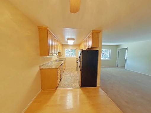A kitchen with wooden cabinets and a black refrigerator.