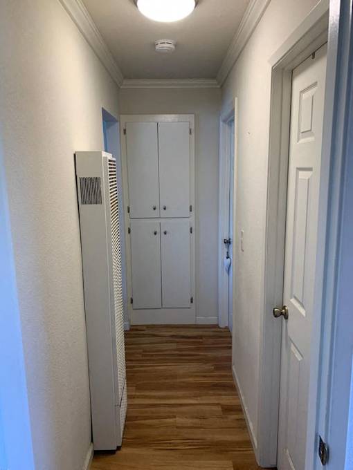 a hallway with wooden floors and white doors