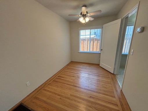 a living room with wood flooring and a ceiling fan