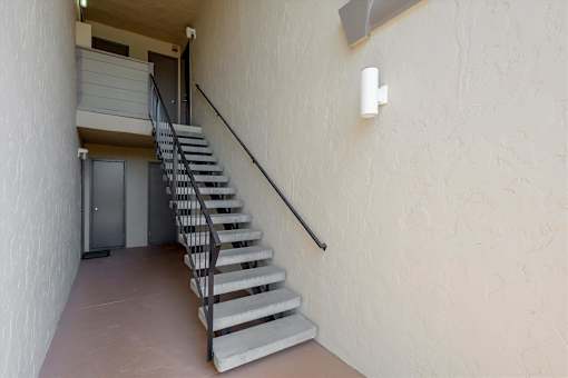 A staircase with a metal railing leads to a door.