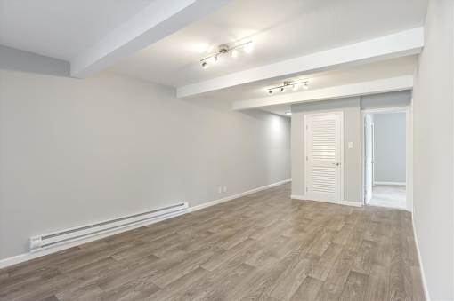 A room with wooden flooring and white walls.