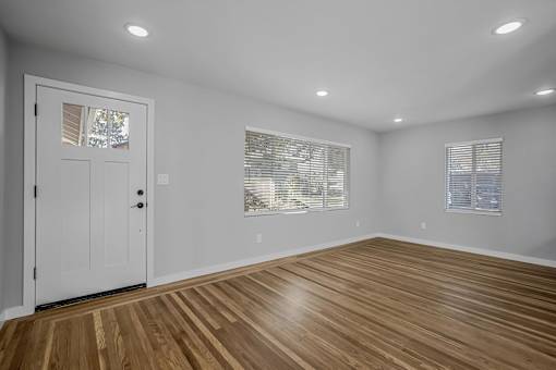 A room with wooden flooring and white walls.