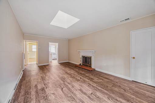 A room with a fireplace and a skylight.