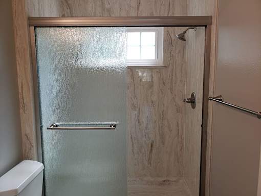 A frosted glass door with a handle and a window in the middle.