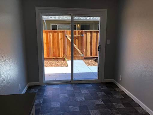 A room with a checkered floor and a door leading to a backyard.