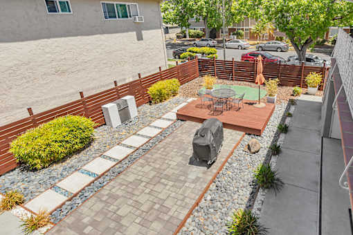 A patio with a table and chairs is surrounded by a brick wall.