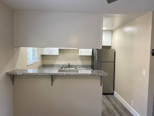 A kitchen with a granite countertop and stainless steel appliances.