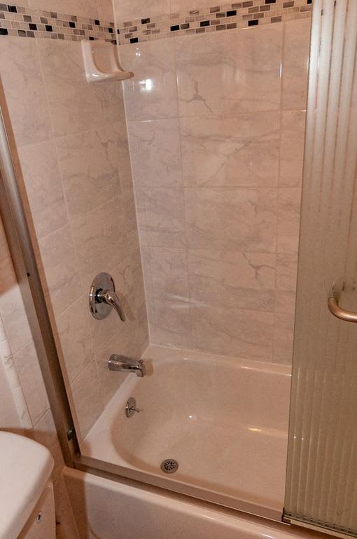 a white bathroom with a shower and a toilet