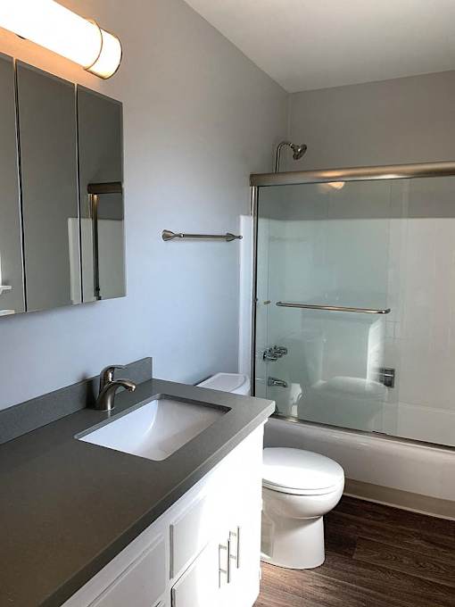 A modern bathroom with a white toilet and a glass shower stall.