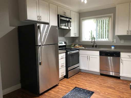 a kitchen with stainless steel appliances and white cabinets