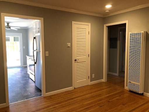 A room with a white door, a white wall, and a white ceiling.