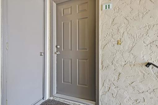 A door is open to a hallway with a wall that has a number 11 on it.