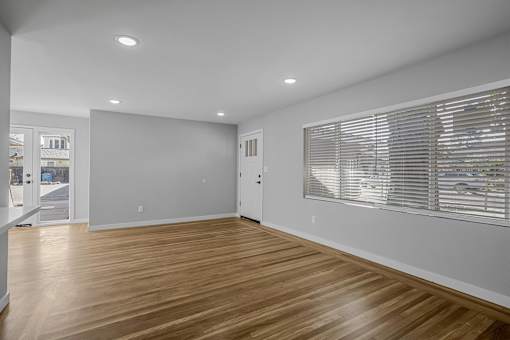 A room with wooden flooring and white walls.