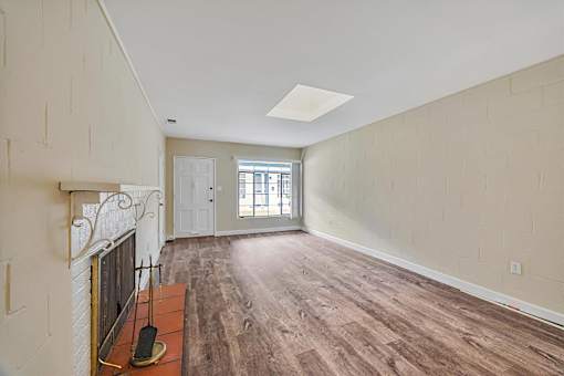 A room with a fireplace and wood flooring.
