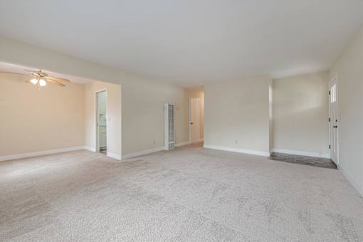 Empty room with carpeted floor and white walls.