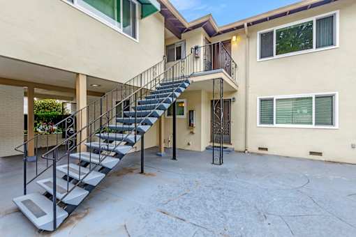 A staircase with a metal railing leads to a balcony.