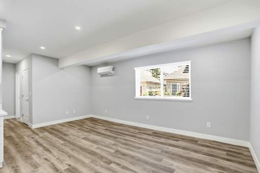 A room with a window and a wooden floor.