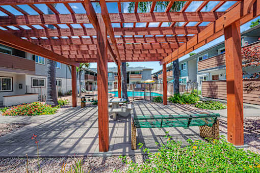 A wooden pergola with a bench underneath it.