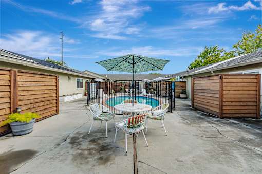 A patio with a pool table and chairs.