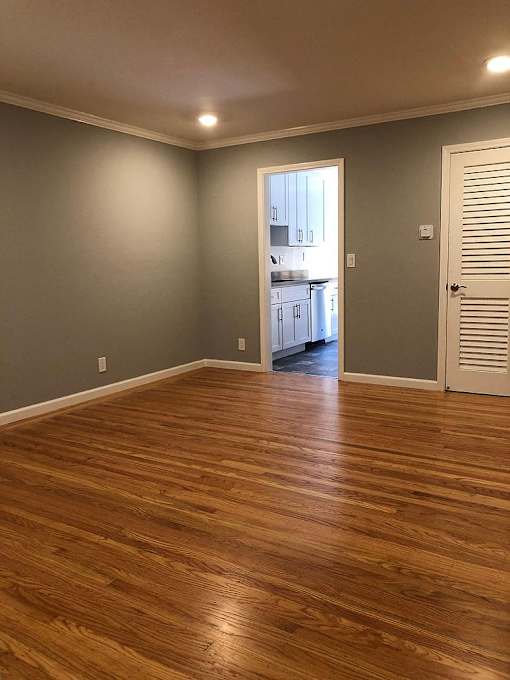 A room with wooden floors and a white door.