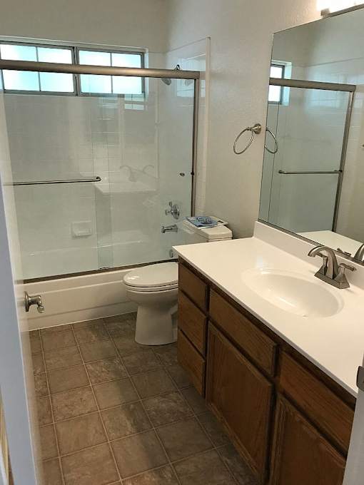 A bathroom with a toilet, sink, and shower.