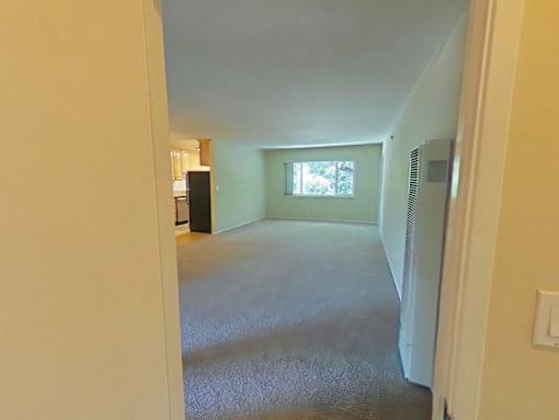 A room with a carpeted floor and a window.