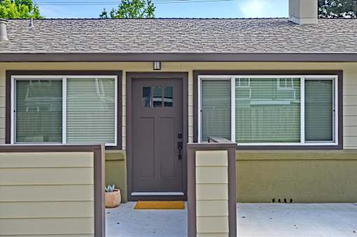 A house with a brown door and a brown fence.