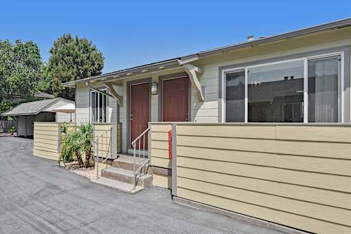 A beige mobile home with a brown door and a small porch.