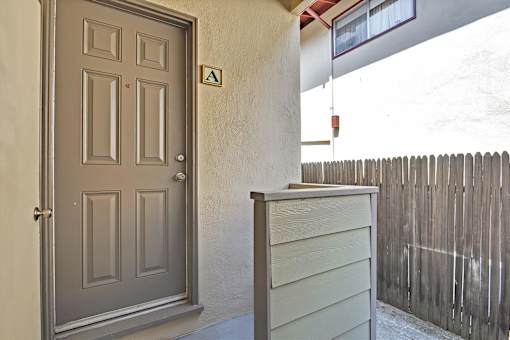 A grey door with a small green square above it.
