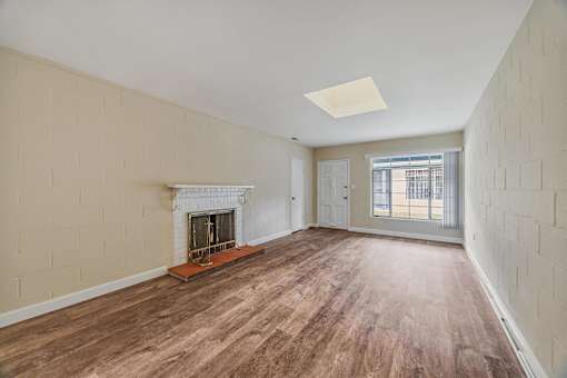 A room with a fireplace and wood flooring.