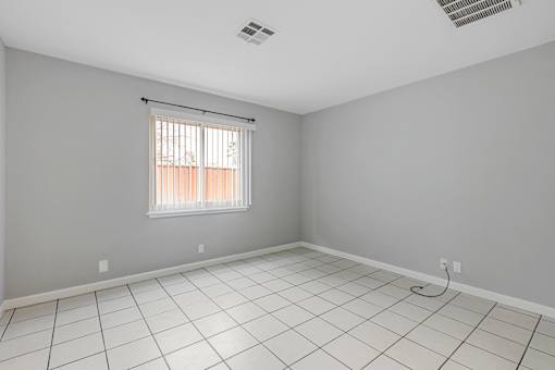 A room with a window and a tiled floor.