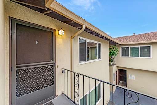 A balcony with a metal railing and a door with a window above it.