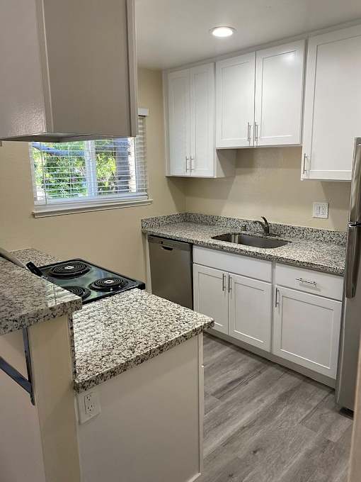 A kitchen with granite countertops and white cabinets.