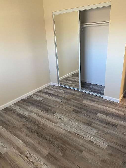 A room with a wooden floor and a white door.