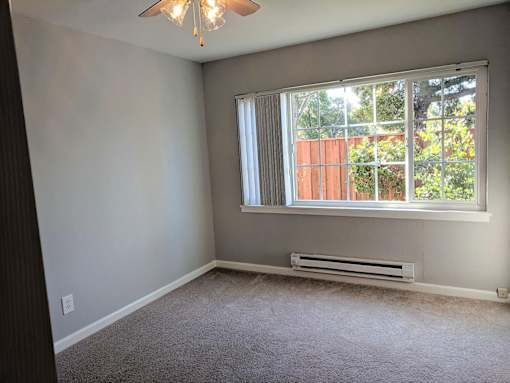 A room with a window and a ceiling fan.