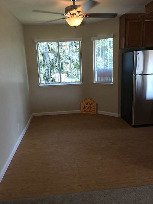 A room with a refrigerator and a sign that says "Now Leasing".