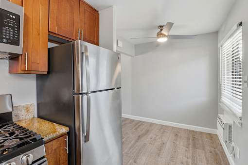 A kitchen with a stove, refrigerator, and cabinets.