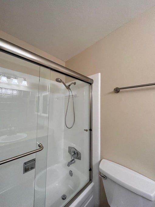 a bathroom with a glass shower and a toilet