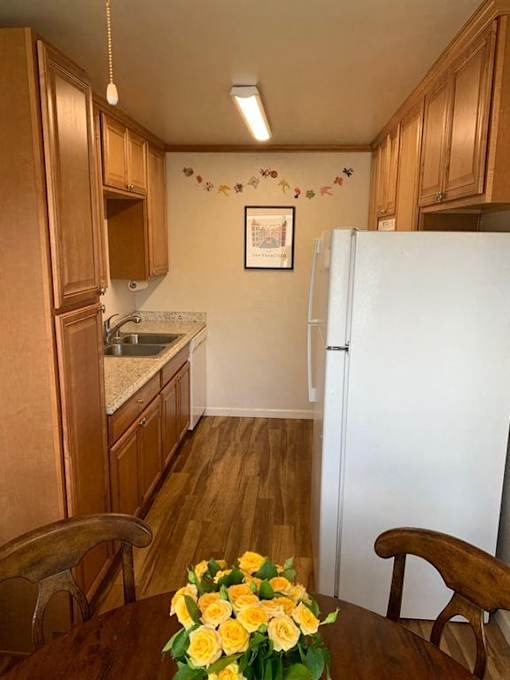 a kitchen with a refrigerator and a table with flowers