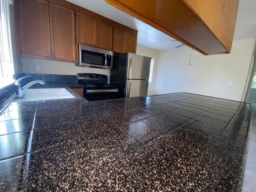 a kitchen with a granite counter top and a refrigerator