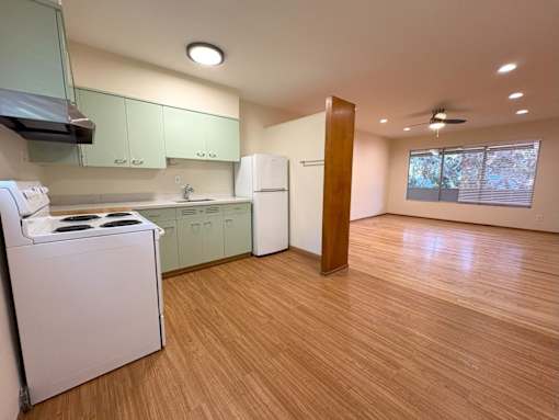 A kitchen with a washing machine and a refrigerator.