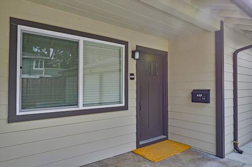 A house with a brown door and a mailbox on the wall.