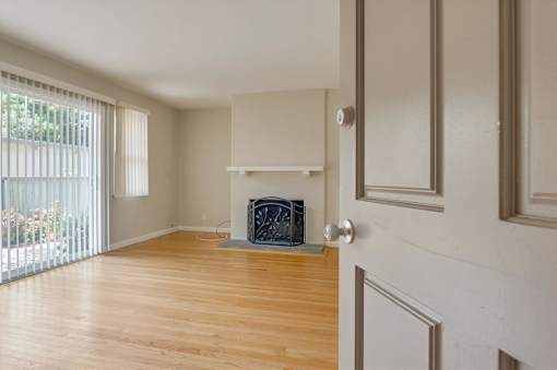 A room with a fireplace and a sliding glass door.