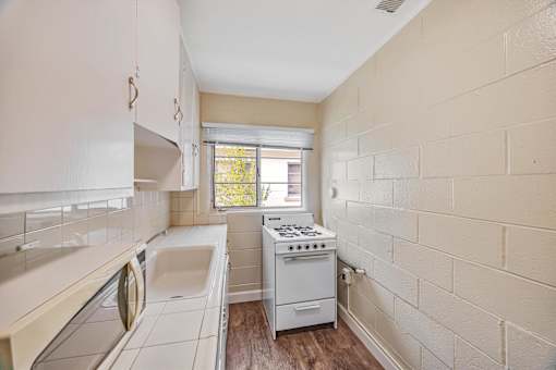 A small kitchen with a washing machine and a stove.