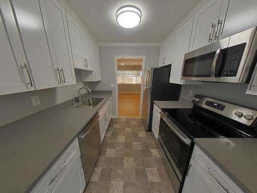 A kitchen with black appliances and white cabinets.