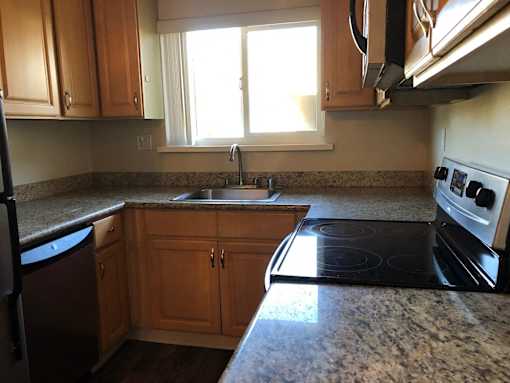 A kitchen with wooden cabinets and granite countertops.