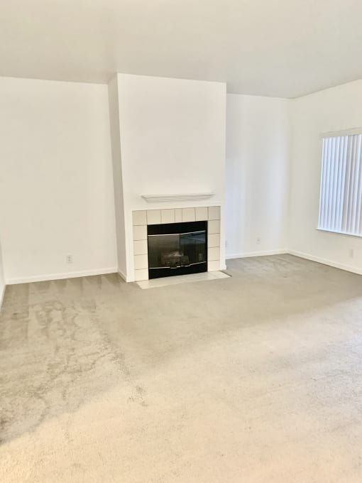 the living room of an empty house with a fireplace