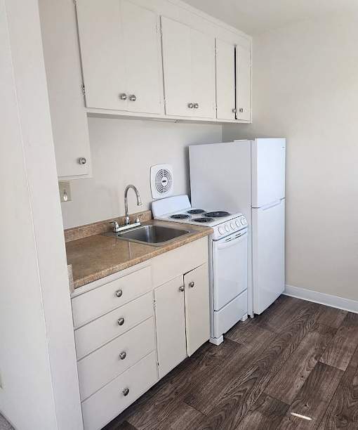 A kitchen with white appliances and cabinets.